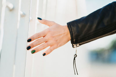 Cropped hand of woman against fence