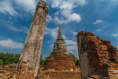 Low angle view of old temple building under blue sky, ayutthaya