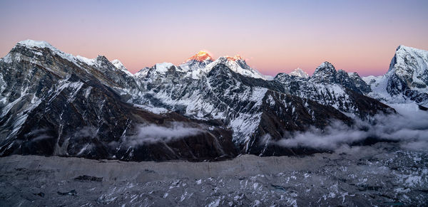 Scenic view of snowcapped mountains against sky during sunset