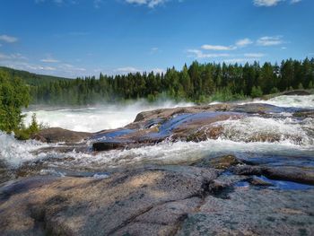 Scenic view of waterfall against sky