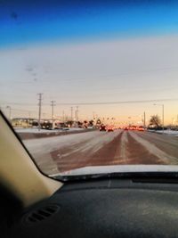 Close-up of cars on road against sky during sunset