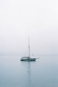 Sailboat sailing on sea against clear sky