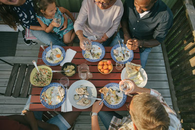 High angle view of multi-generation family having lunch at table on porch