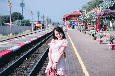 Portrait of smiling woman standing on railroad station platform