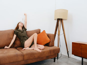 Woman sitting on sofa at home