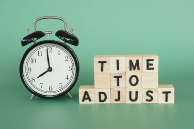 Close-up of alarm clock against green background
