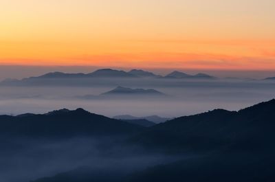 Scenic view of silhouette mountains against romantic sky at sunset