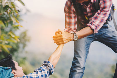 Midsection of couple holding hands