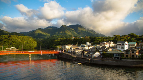 Scenic view of river by mountains against sky