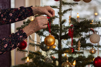 Woman's hands decorating christmas tree