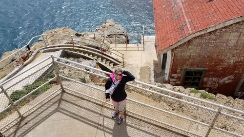 Rear view of woman walking on staircase in city