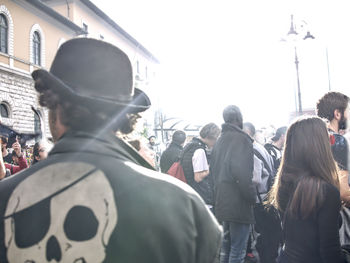 Rear view of people standing on street in city