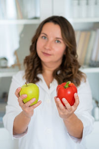 Portrait of young woman holding apple