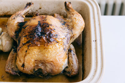 Close-up of roast chicken in container on table