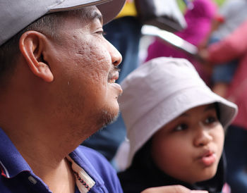 Close-up of father by daughter looking away outdoors