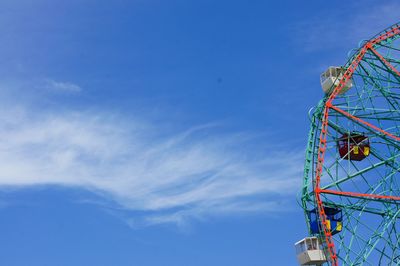 Low angle view of ferris wheel against blue sky