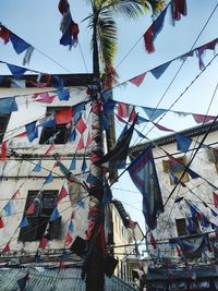 Low angle view of flags hanging against sky