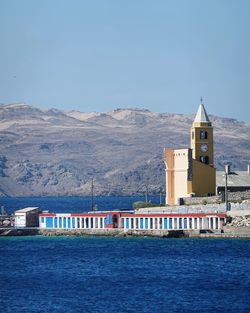 View of buildings by sea against clear sky