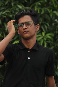 Portrait of young man wearing sunglasses standing outdoors