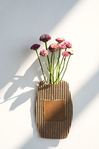Small bouquet of flowers in cardboard vase.