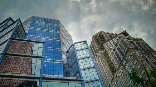 Low angle view of modern building against cloudy sky