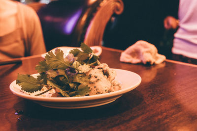 Close-up of hand holding food in plate