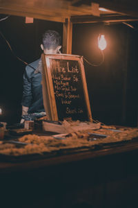 Reflection of man on table at night