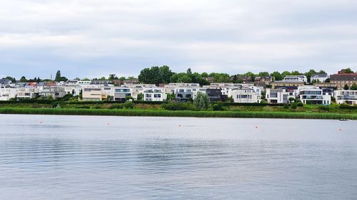 River by buildings in town against sky