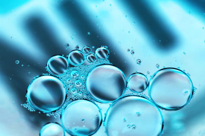 Close-up of water on illuminated glass table