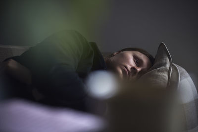 Sad man facing depression lying in bed