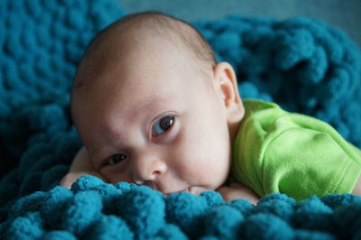 Close-up portrait of cute baby lying on bed