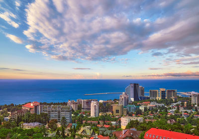 High angle view of buildings by sea against sky