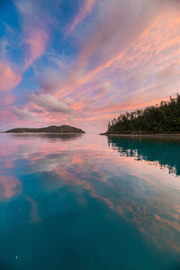 Scenic view of sea against dramatic sky during sunset