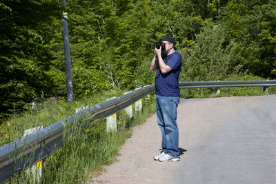 Full length of man standing on mobile phone