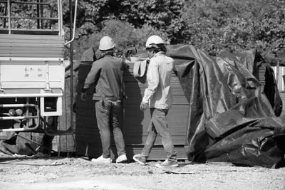 Rear view of men working at construction site