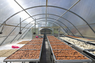 Railroad tracks in greenhouse against sky