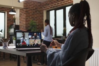 Side view of woman using laptop at home