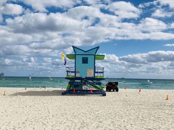 Lifeguard hut on beach against sky