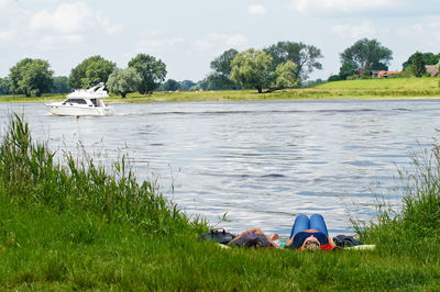Man and woman lying on grass at elbe riverbank