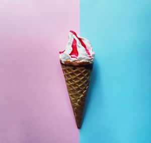 Close-up of ice cream cone on colored background