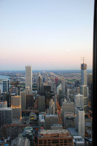 Aerial view of buildings in city against clear sky