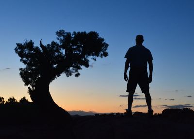 Rear view of silhouette man standing against clear sky