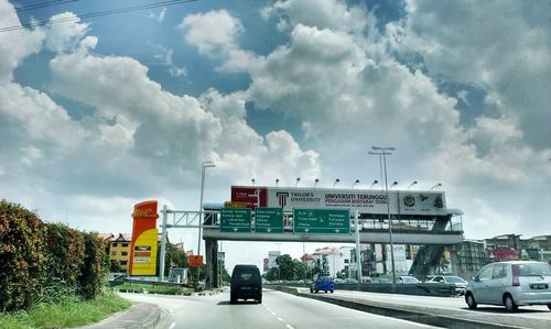 Road sign against cloudy sky