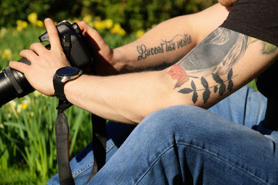 Man with tattoos taking photos