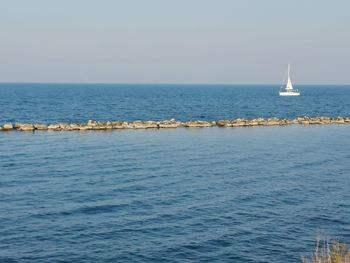 Sailboat sailing on sea against sky