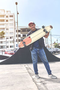 The perfect way to get through these streets, teenager in street clothes stands with a longboard