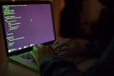 Midsection of man using laptop on table