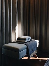 Books on seat by curtains at home