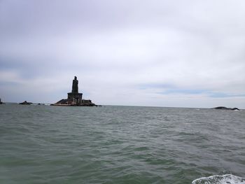 Lighthouse by sea against sky at kanyakumari