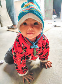 High angle view of cute baby girl standing against wall